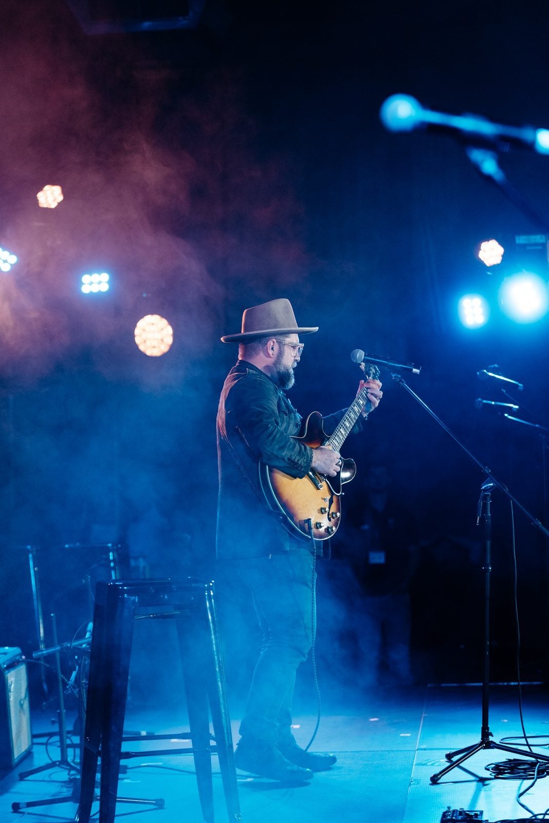 Musician performing solo on stage at an Unsung Hero benefit concert