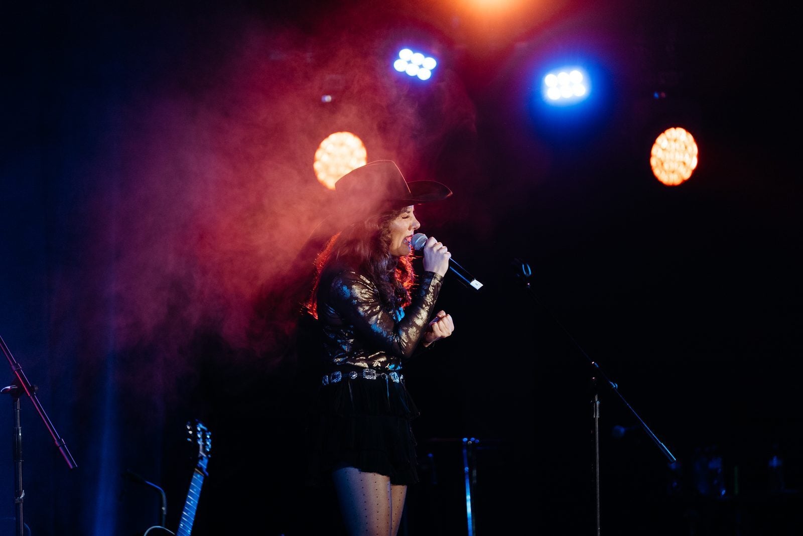 Vocalist performing on stage at an Unsung Hero benefit concert
